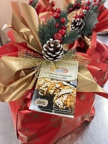 Panettone incartato a mano con nastro dorato e pigna decorativa