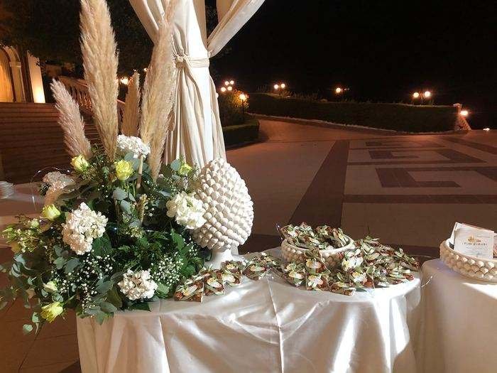 Allestimento bomboniere per eventi con pigna bianca e fiori